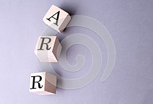 Word ARR on wooden block on the grey background