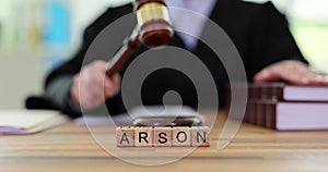 Word Arson against woman judge knocking gavel at desk