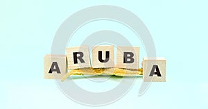 Word Aruba made with wooden cubes and starfish on mint green