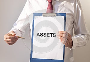Word Assets on paper in businessman hand Financial accounting. Money concept