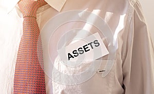 Word Assets on paper in businessman pocket. Financial accounting. Money concept