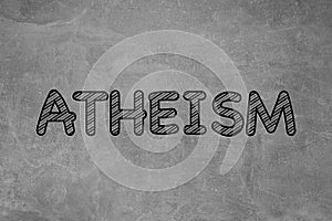 Word Atheism on grey stone surface. Philosophical or religious position