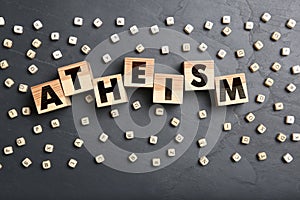 Word Atheism made of wooden cubes with letters on grey table, flat lay