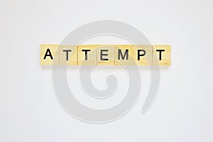 Word attempt. Top view of wooden blocks with letters on white surface