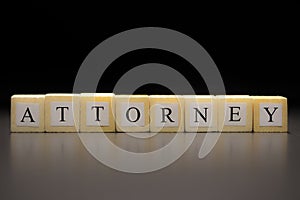 The word ATTORNEY written on wooden cubes isolated on a black background