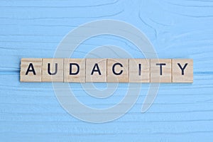 word audacity made from wooden gray letters lies