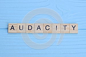 word audacity made from wooden gray letters lies photo