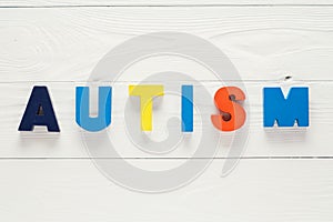 Word Autism built of colorful wooden blocks on wooden background