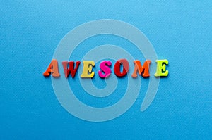 Word awesome from plastic magnetic letters on blue background