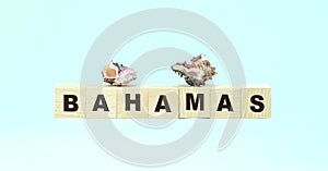 Word Bahamas made with wooden cubes and shells on turquoise