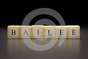 The word BAILEE written on wooden cubes isolated on a black background