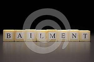 The word BAILMENT written on wooden cubes isolated on a black background