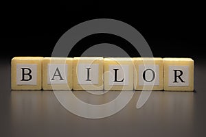 The word BAILOR written on wooden cubes isolated on a black background