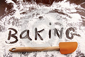 Word baking written in white flour on wooden table