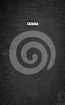 Word beef on black stone background