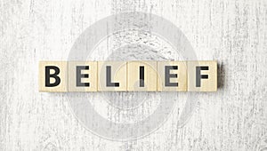 Word BELIEF made with wood building blocks