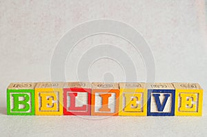 The word believe spelled with colorful alphabet blocks