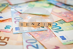 The word Benzin - in German for Gasoline - on banknotes Euro notes written with wooden cubes photo