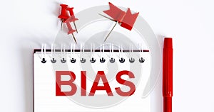 The word BIAS is written in the notebook with office tools
