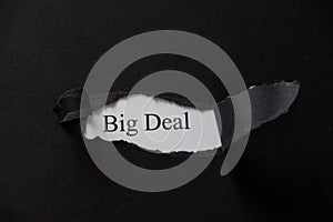 Word BIG DEAL printed on a white background with black torn paper