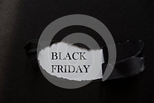 Word BLACK FRIDAY printed on a white background with black torn paper