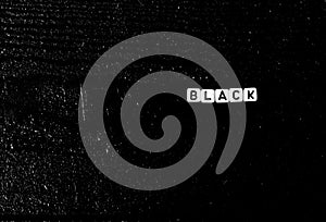 The word `black` is made of cubes on a black wooden background. black background,