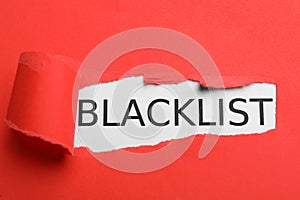 Word Blacklist on white background through hole in red paper, top view