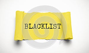 Word Blacklist on white background through hole in yellow paper, top view