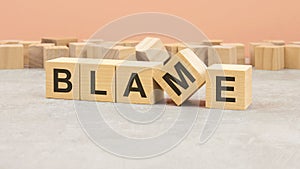 word Blame made with wood blocks. text is written in black letters, light background