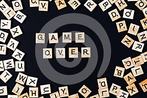 Word BOARD GAME with wooden letters on black board and letter in the circle