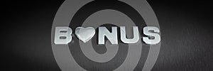 Word bonus spelled with chrome letters in a conceptual image with silver heart replacing letter o.