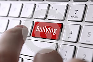 word bullying on the computer's gray keyboard. The concept of harassment intimidation and humiliation in the network