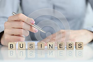 Word business and a businessman is holding pen and document