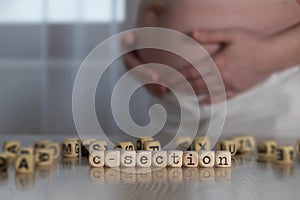 Word C-SECTION composed of wooden letters