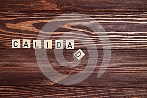 Calidad, quality spanish word, lettering on wooden background photo