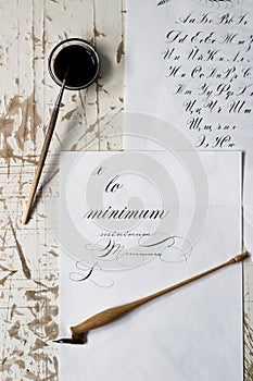 Word Calligraphy written on paper, with calligraphy tools in background