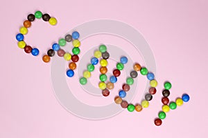 The word candy are contained by colored candies on a pink background