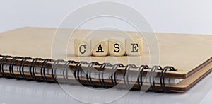 Word CASE made with letters on wooden blocks on wooden notepad