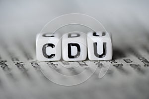 Word CDU formed by wood alphabet blocks on newspaper german party politics photo