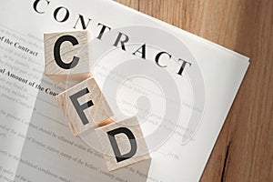 Word CFD - Contract For Difference, on wooden cubes on contract documents background