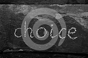 The word CHOICE written with chalk on black stone