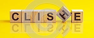 Word CLICHE made with wood building blocks on a bright yellow back ground