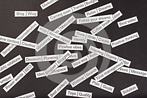 Word cloud of business themes cut out of paper on a gray background