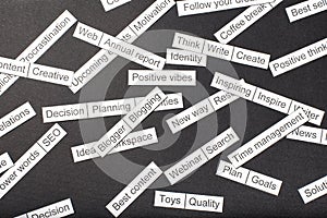 Word cloud of business themes cut out of paper on a gray background