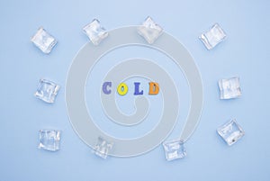 The word COLD on a blue background of wooden multicolored letters, ice cubes around the word