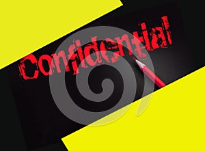 The word confidential yellow on black and a pencil besides. Secret personal or business data concept