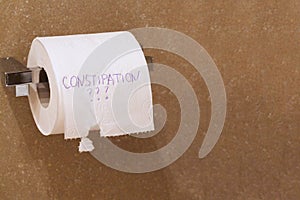 The word constipation written on a tolet paper photo