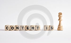 The word content is king written on wooden blocks with a king chess piece