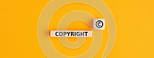 The word copyright and copyright symbol on wooden blocks. Concept of patenting or copyright protection