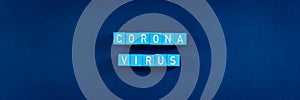 Word corona virus spelled in white text on light blue blocks in a conceptual image